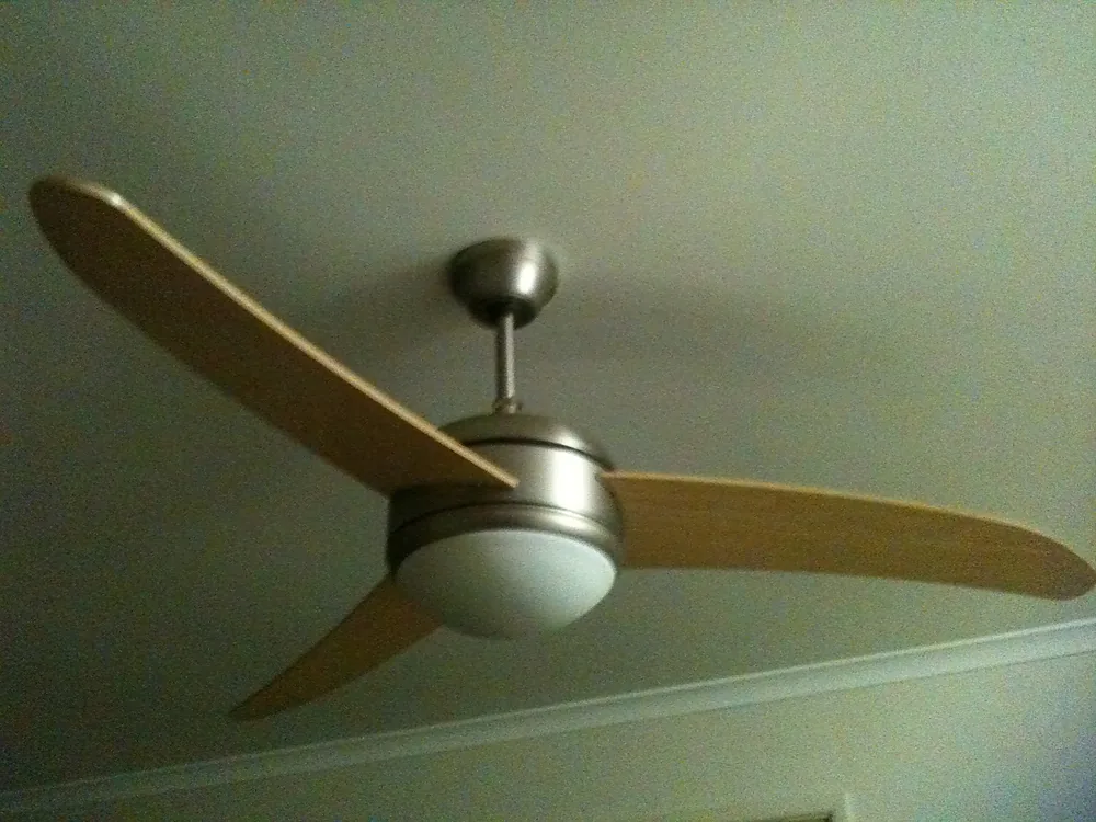 A ceiling fan with timber blades and a light, installed by Michael TN Electrical