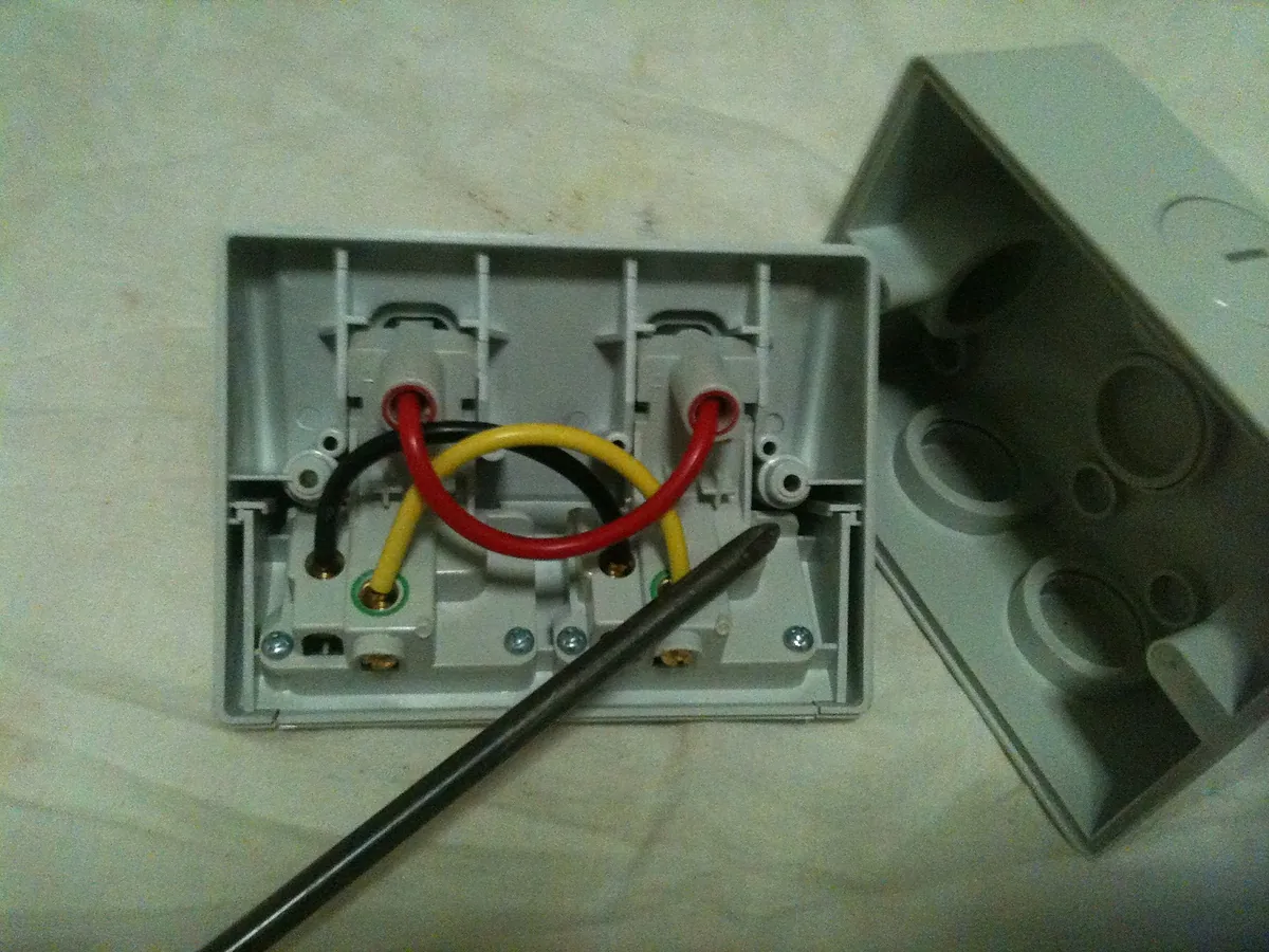 A double power point opened up showing its active, neutral and earth wiring
