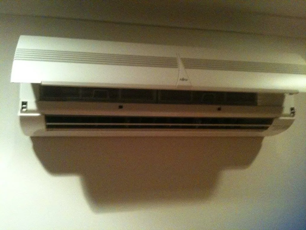 A split system indoor unit opened up on a bedroom wall for servicing